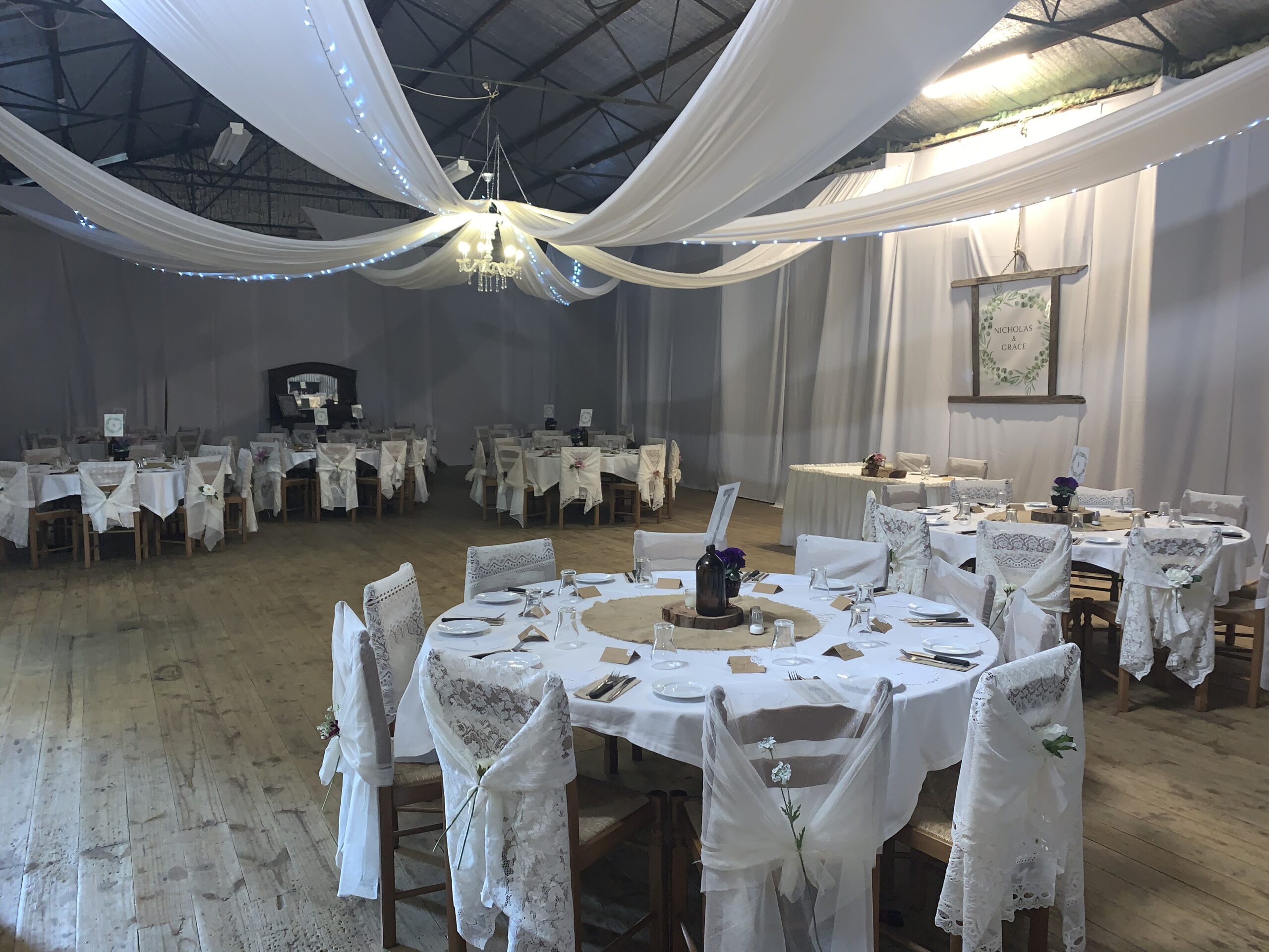 Draped ceiling above round tables set for a wedding