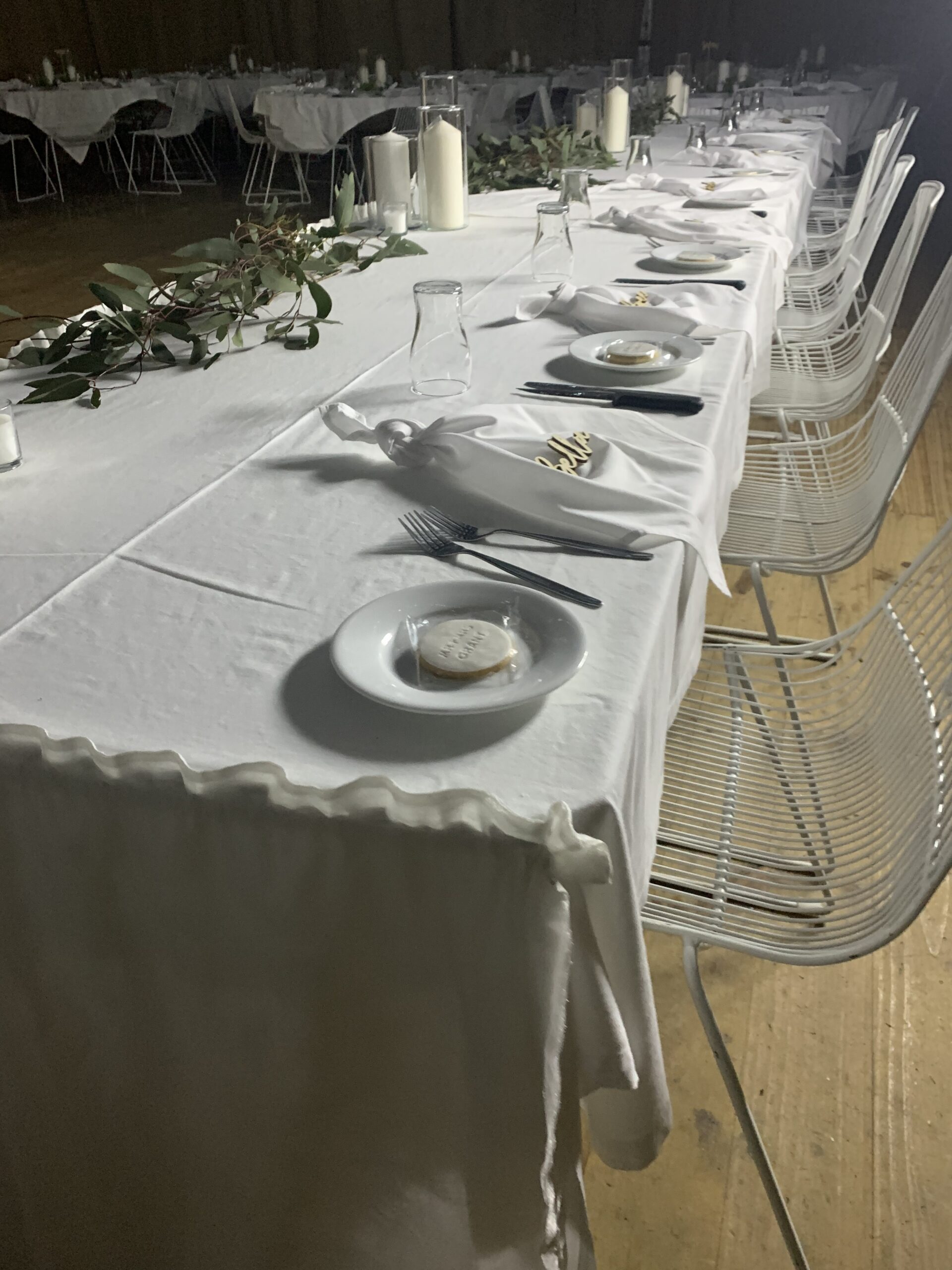 Place settings along a long table with a greenery runner