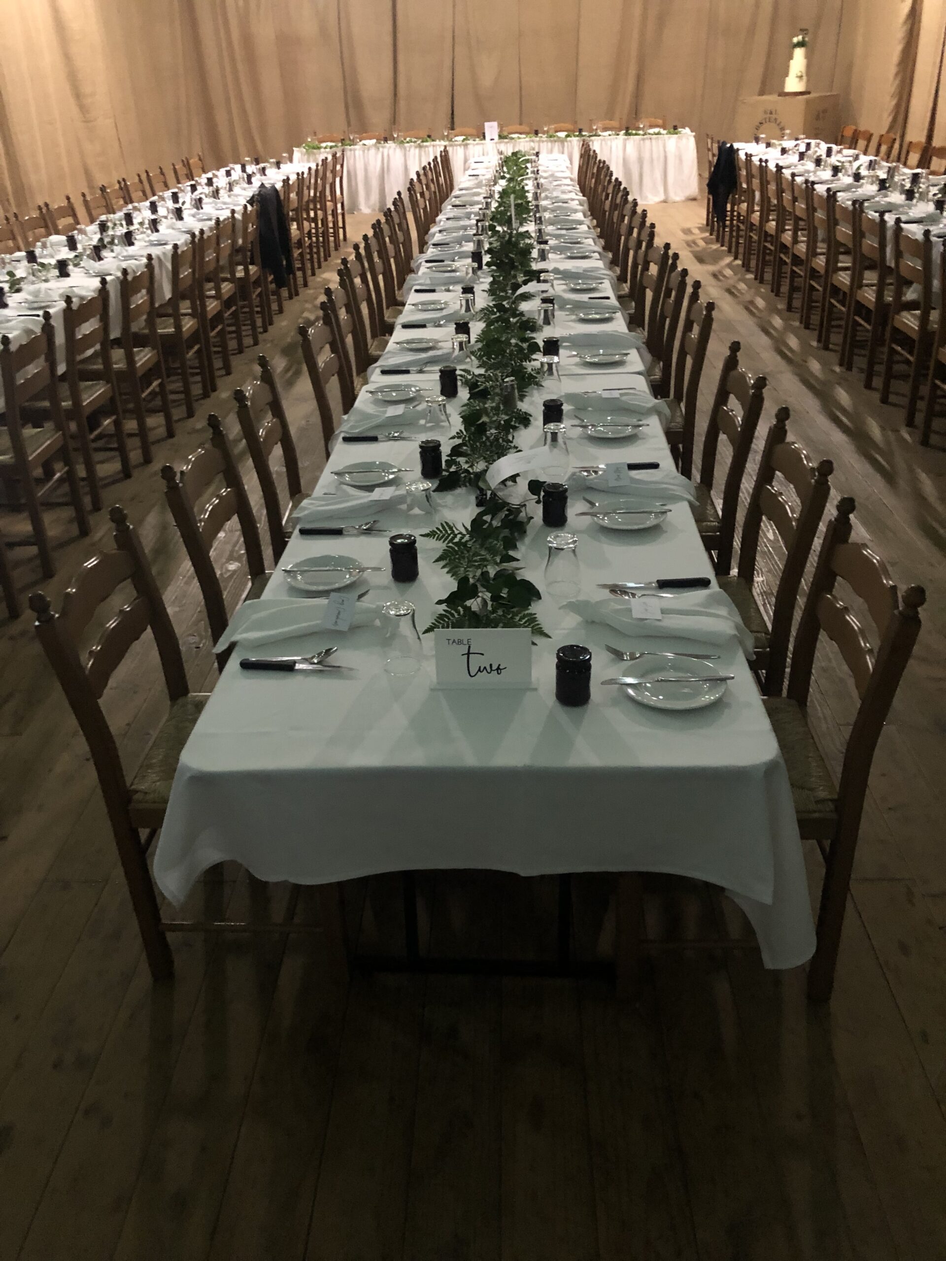 Two long banquet rows set down the drying shed